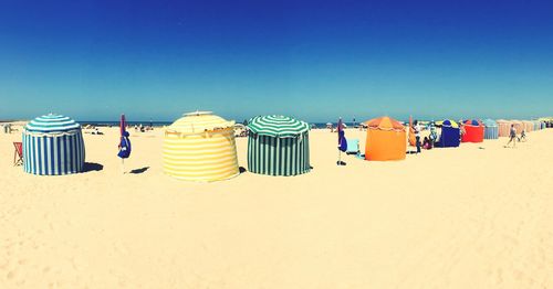 Multi colored umbrellas on beach against clear blue sky