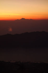 Scenic view of silhouette mountains against romantic sky at sunset