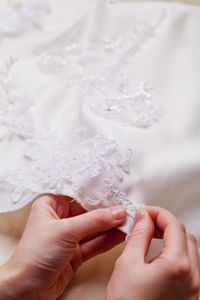 Cropped hands of woman stitching wedding dress