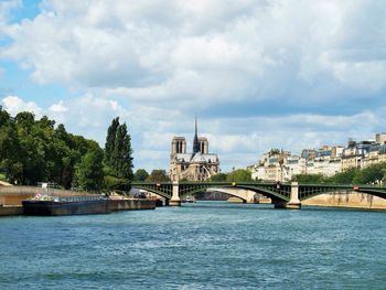 Pont notre-dame over river seine against cloudy sky