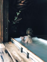 Full length of shirtless boy sitting in swimming pool