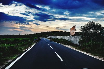 Empty road against cloudy sky