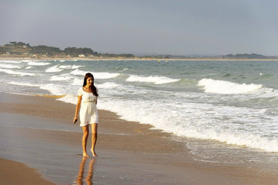 Rear view of woman standing on beach