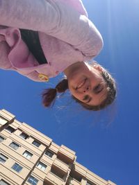 Close-up portrait of happy girl against blue sky