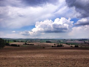 Scenic view of field against cloudy sky