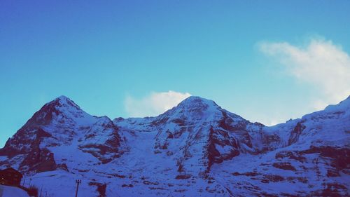 Scenic view of snowcapped mountains against blue sky