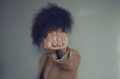 Closeup and selective focus on a black woman fist with rings. afro puff hair.