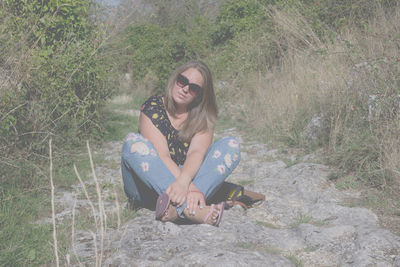 Portrait of smiling young woman sitting on land