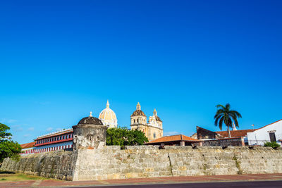 Low angle view of castle against clear blue sky on sunny day