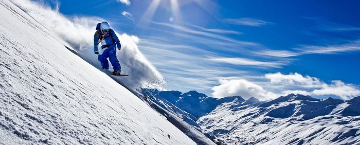 Person skiing on snowcapped mountain against sky