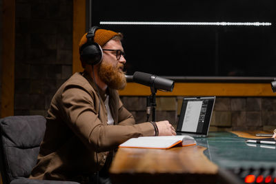 Male podcaster interviewing a guest in a recording studio