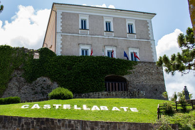 Built structure by lawn against sky