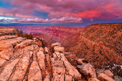 Rock formations on landscape against cloudy sky