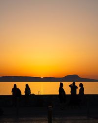 Silhouette people at beach during sunset