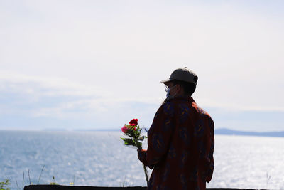 Man standing by sea against sky