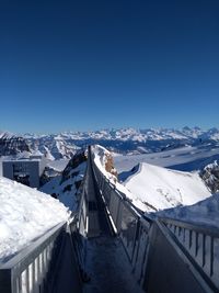 Panoramic view of snowcapped mountains against clear blue sky