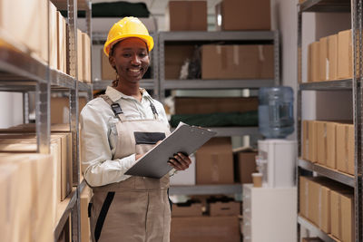 Portrait of young woman standing in factory