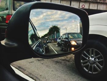 Reflection of sky on side-view mirror of car