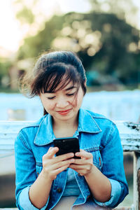 Young woman using mobile phone outdoors