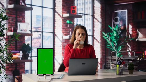 Portrait of young woman using mobile phone while standing in cafe