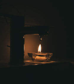 Close-up of illuminated tea light candles in darkroom