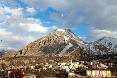 Town by mountain against sky