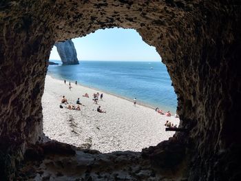People on beach seen through arch