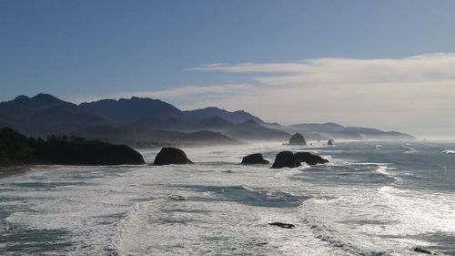 Scenic view of sea and mountains against sky