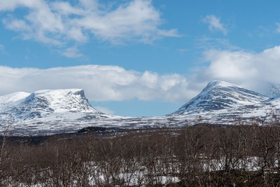 Scenic view of snowcapped mountain against cloudy sky