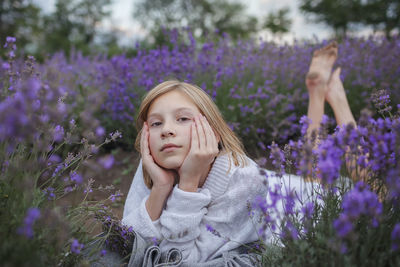 Low angle view of woman with purple flowers on land