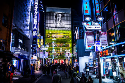 People walking on city street at night