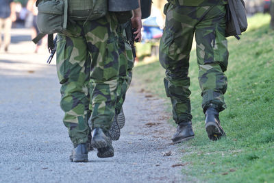 Low section of army soldiers walking on road