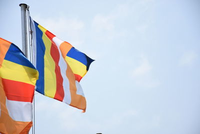 Low angle view of flag against blue sky