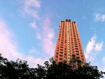 Low angle view of skyscraper against cloudy sky