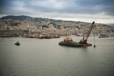 Sailboats in sea against sky in city