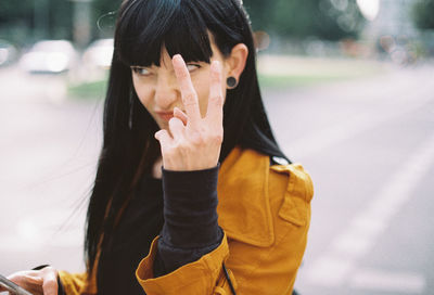 Close-up of young woman gesturing outdoors