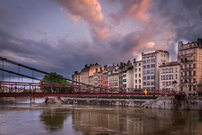 Bridge over river against cloudy sky