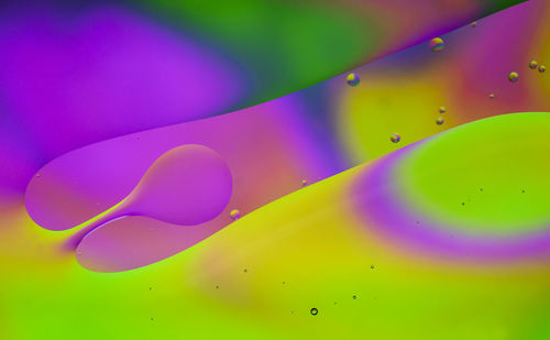 Close-up of water drops on multi colored background