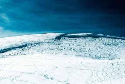 Scenic view of snowcapped mountains against blue sky