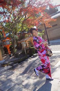 Low angle view of girl and plants against trees