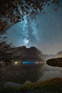 Scenic view of lake and mountains against sky at night