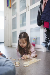 Girl lying on floor and doing jigsaw puzzles