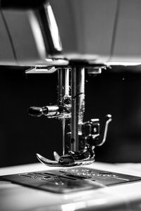 Close-up of sewing machine against black background