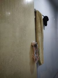 Man holding umbrella against wall in bathroom