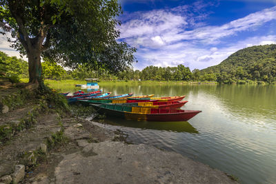 Boat moored in lake against sky