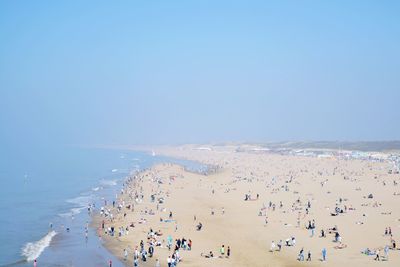 People on beach against clear sky