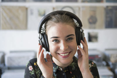 Smiling young woman listening to music in a record store