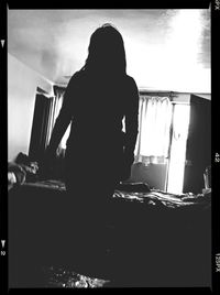 Rear view of silhouette woman standing against sky