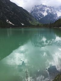 Scenic view of lake by mountains against sky