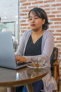 Businesswoman using laptop at cafe